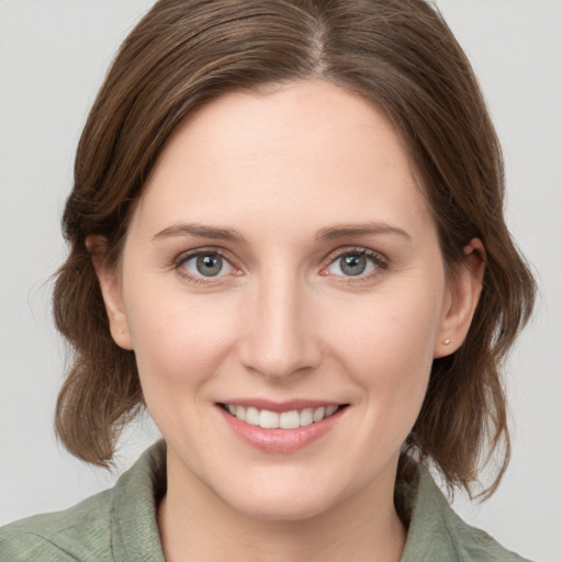 Joyful white young-adult female with medium  brown hair and green eyes