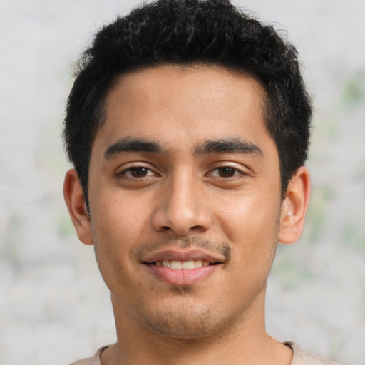 Joyful latino young-adult male with short  black hair and brown eyes