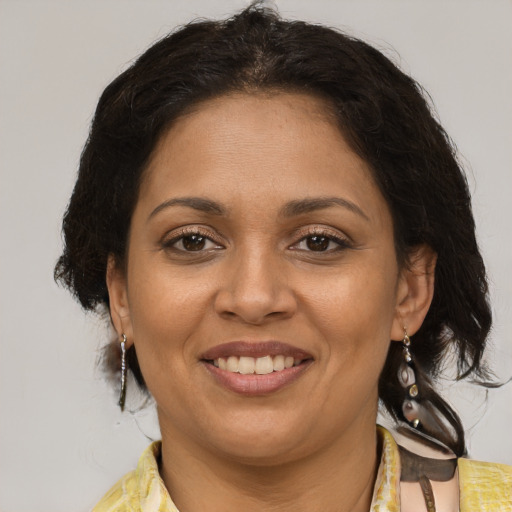 Joyful latino adult female with medium  brown hair and brown eyes