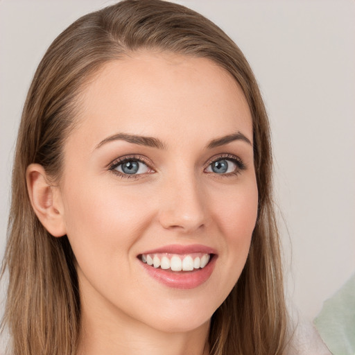 Joyful white young-adult female with long  brown hair and blue eyes