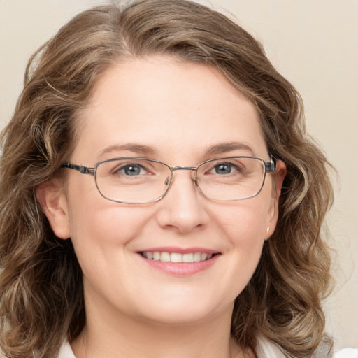 Joyful white adult female with medium  brown hair and green eyes