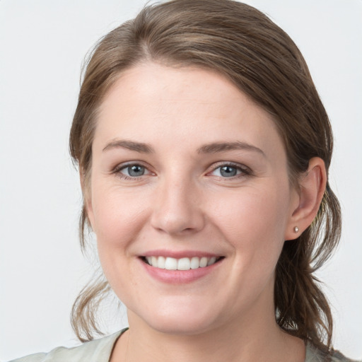 Joyful white young-adult female with medium  brown hair and grey eyes