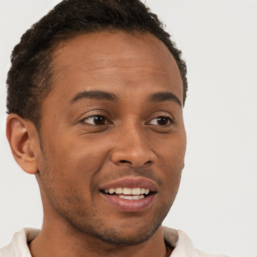 Joyful black young-adult male with short  brown hair and brown eyes