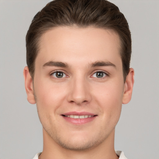 Joyful white young-adult male with short  brown hair and grey eyes