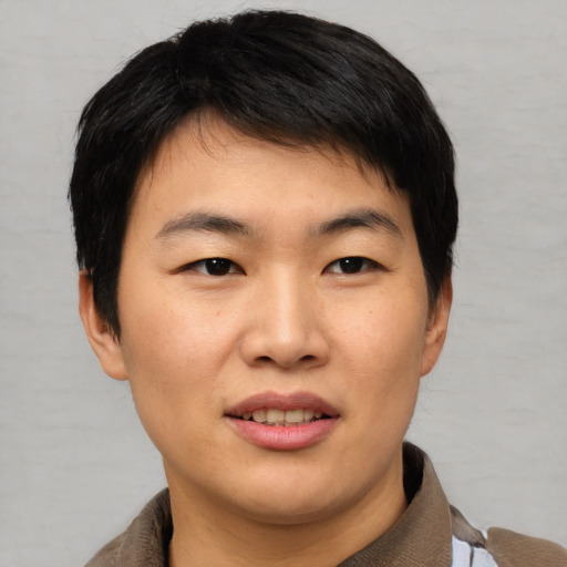 Joyful asian young-adult male with short  brown hair and brown eyes