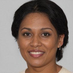 Joyful black adult female with medium  brown hair and brown eyes