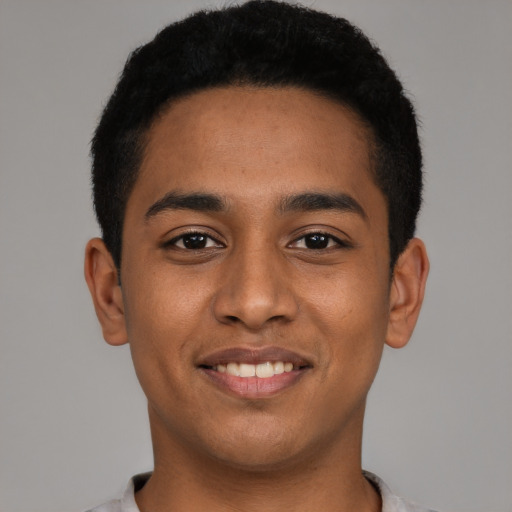 Joyful latino young-adult male with short  black hair and brown eyes