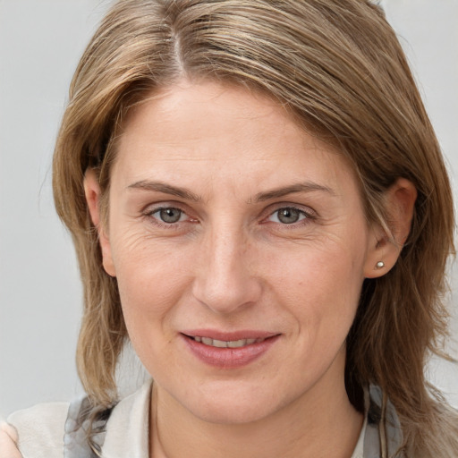 Joyful white adult female with medium  brown hair and grey eyes