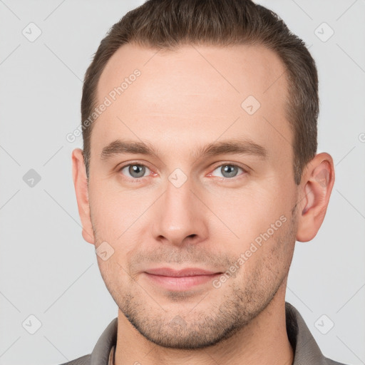 Joyful white young-adult male with short  brown hair and grey eyes