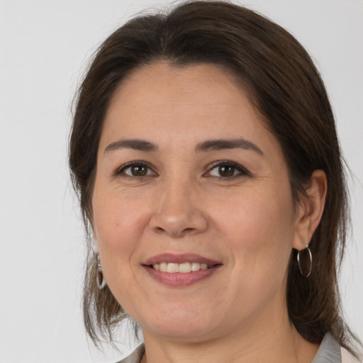 Joyful white adult female with medium  brown hair and brown eyes