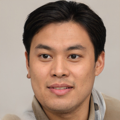 Joyful asian young-adult male with short  brown hair and brown eyes