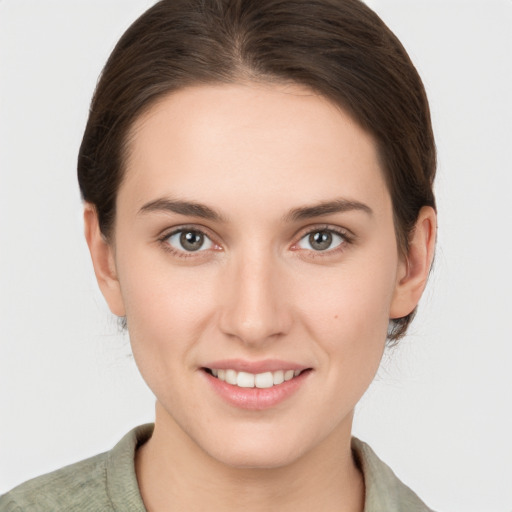 Joyful white young-adult female with medium  brown hair and grey eyes