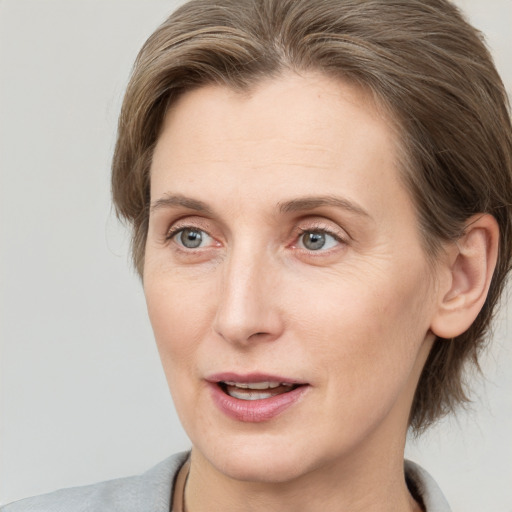 Joyful white adult female with medium  brown hair and grey eyes