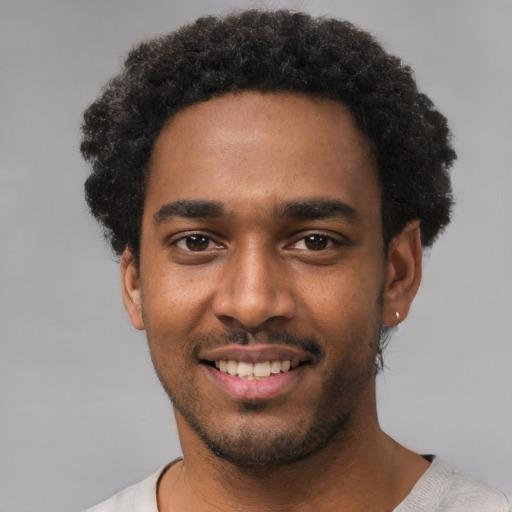 Joyful black young-adult male with short  black hair and brown eyes