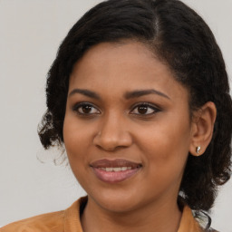 Joyful black young-adult female with long  brown hair and brown eyes