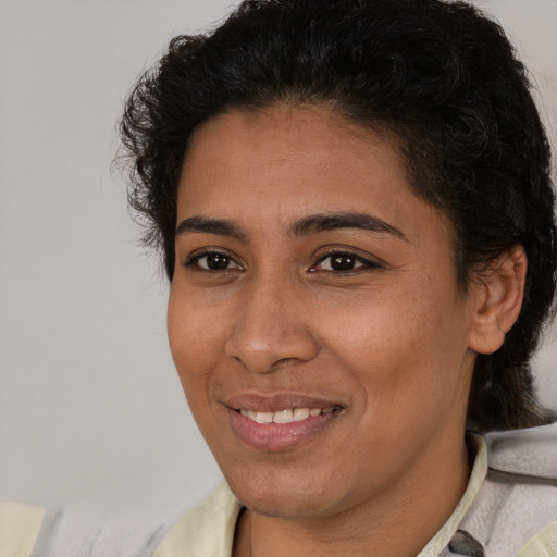 Joyful latino young-adult female with short  black hair and brown eyes