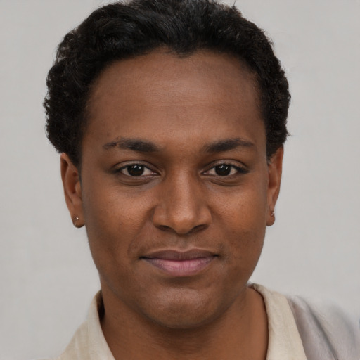 Joyful black young-adult female with short  brown hair and brown eyes