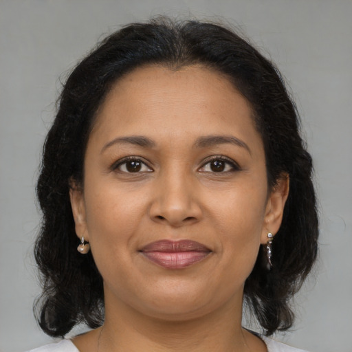Joyful latino young-adult female with medium  brown hair and brown eyes