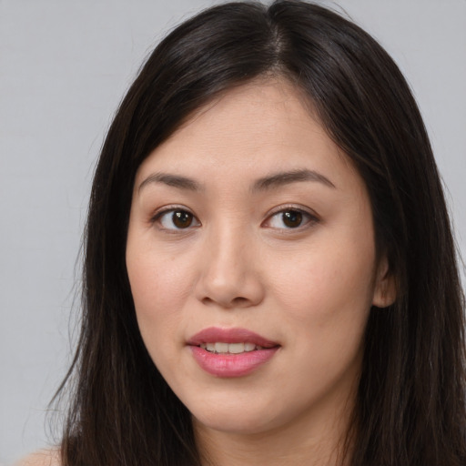 Joyful asian young-adult female with long  brown hair and brown eyes