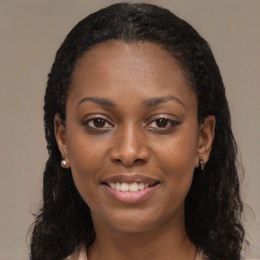 Joyful black young-adult female with long  black hair and brown eyes