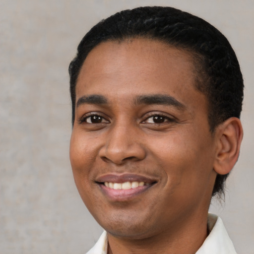 Joyful latino young-adult male with short  black hair and brown eyes