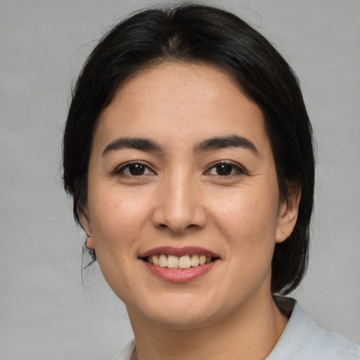 Joyful asian young-adult female with medium  black hair and brown eyes