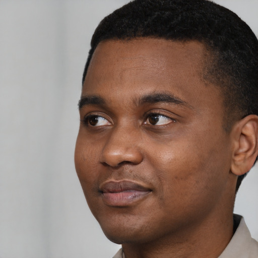 Joyful black young-adult male with short  black hair and brown eyes