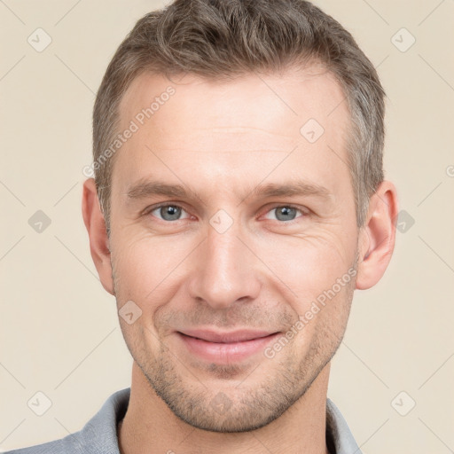 Joyful white young-adult male with short  brown hair and grey eyes