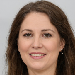 Joyful white adult female with long  brown hair and brown eyes
