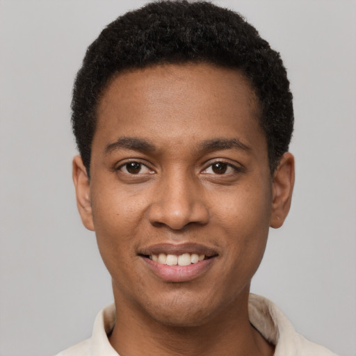 Joyful black young-adult male with short  black hair and brown eyes