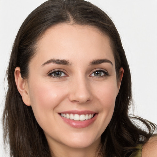 Joyful white young-adult female with long  brown hair and brown eyes