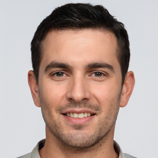 Joyful white young-adult male with short  brown hair and brown eyes