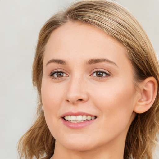 Joyful white young-adult female with long  brown hair and blue eyes