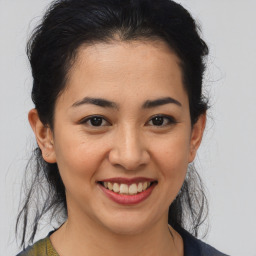 Joyful latino young-adult female with medium  brown hair and brown eyes