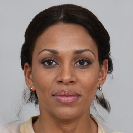 Joyful black adult female with medium  brown hair and brown eyes