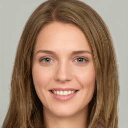 Joyful white young-adult female with long  brown hair and green eyes