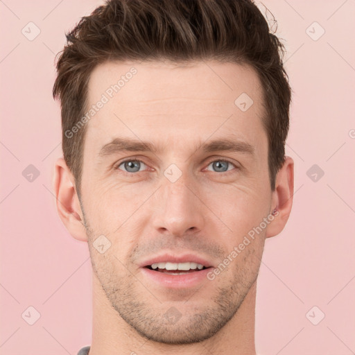 Joyful white young-adult male with short  brown hair and grey eyes