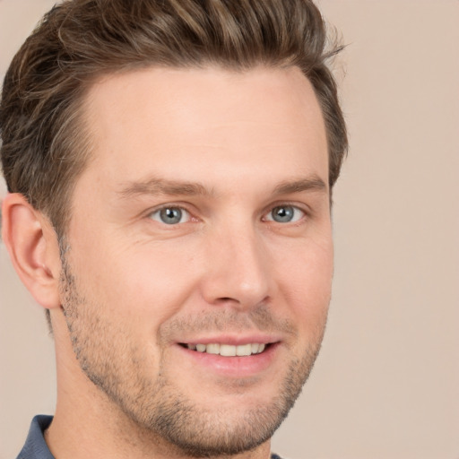 Joyful white young-adult male with short  brown hair and grey eyes