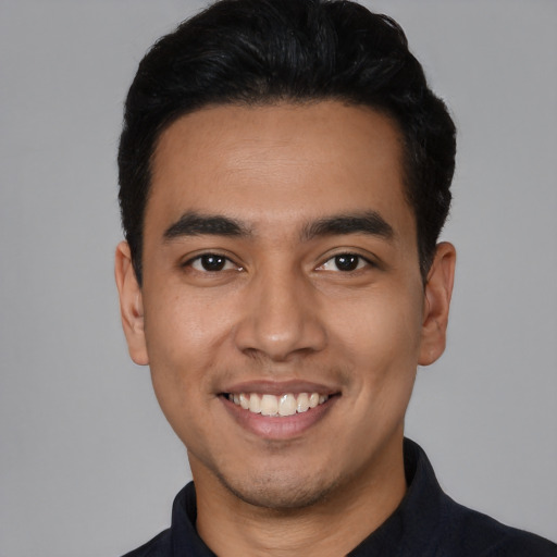 Joyful latino young-adult male with short  black hair and brown eyes