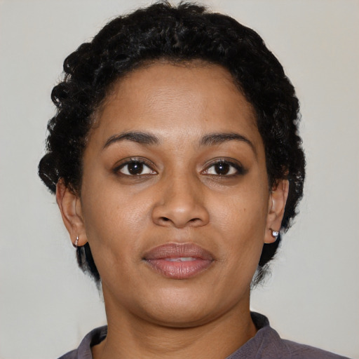 Joyful black young-adult female with short  black hair and brown eyes