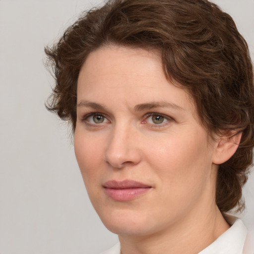 Joyful white young-adult female with medium  brown hair and green eyes