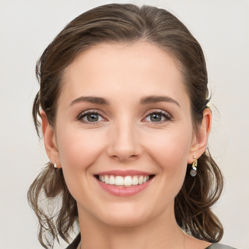 Joyful white young-adult female with medium  brown hair and green eyes