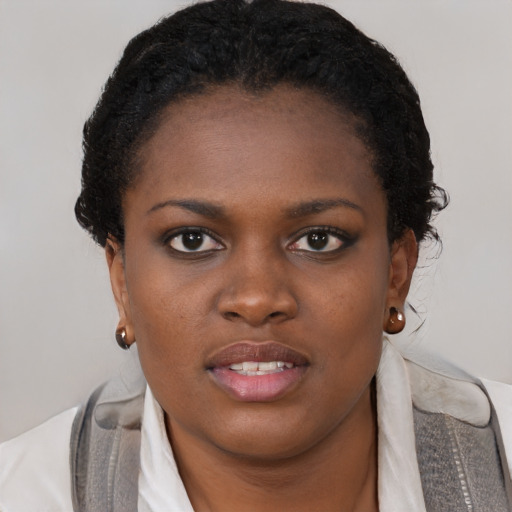 Joyful black young-adult female with short  brown hair and brown eyes