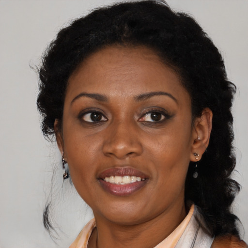 Joyful black adult female with long  brown hair and brown eyes