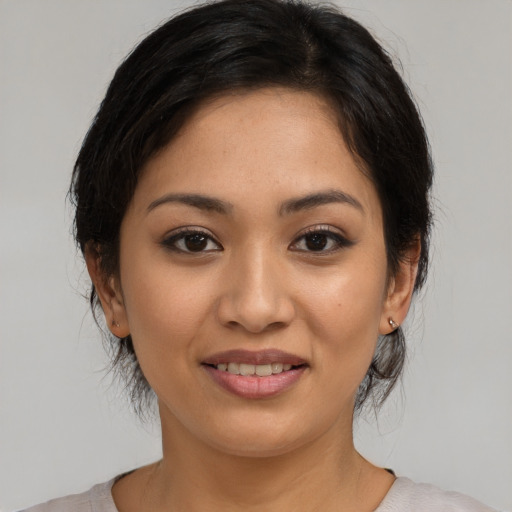 Joyful latino young-adult female with medium  brown hair and brown eyes