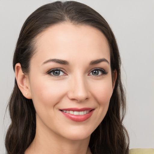 Joyful white young-adult female with long  brown hair and brown eyes