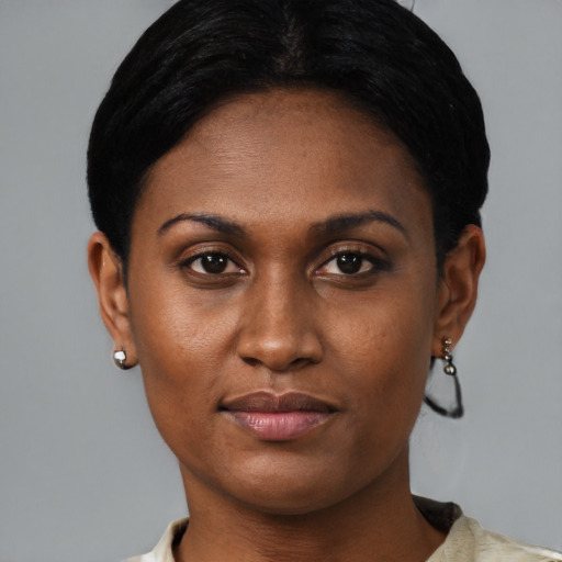 Joyful black young-adult female with short  black hair and brown eyes