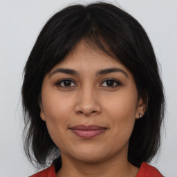 Joyful latino young-adult female with long  brown hair and brown eyes