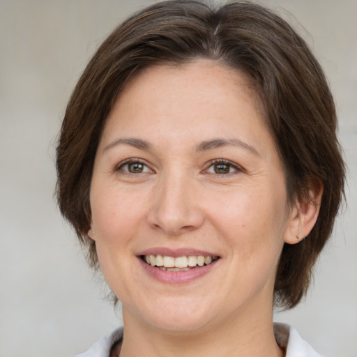 Joyful white adult female with medium  brown hair and brown eyes