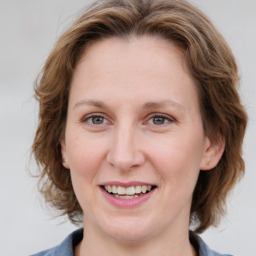 Joyful white young-adult female with medium  brown hair and blue eyes